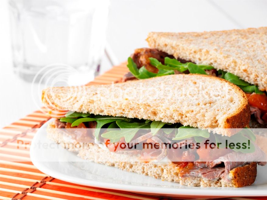 A close up of a sandwich on a plate, with Beef and Tomato